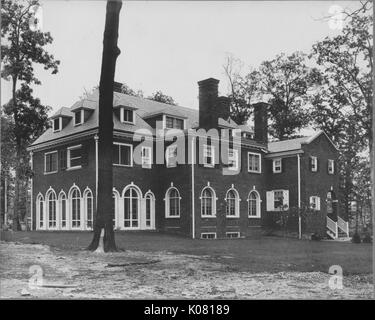 Photographie d'un grand trois étages Roland Park Home à Baltimore, fait presque entièrement en briques, avec de grandes fenêtres blanches, entouré par de grands arbres, situé sur l'herbe éparse, United States, 1920. Cette image est tirée d'une série sur la construction et la vente de maisons dans le quartier Roland Park/Guilford de Baltimore, a streetcar suburb et l'une des premières communautés planifiées aux États-Unis. Banque D'Images