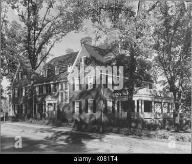 Photographie d'un grand parc Roland home fait de brique, avec deux grands balcons, une maison de deux étages de fenêtres, pas de cour avant, le porche a deux colonnes doriques, et la maison est ombragée par de nombreux arbres feuillus, United States, 1950. Cette image est tirée d'une série sur la construction et la vente de maisons dans le quartier Roland Park/Guilford de Baltimore, a streetcar suburb et l'une des premières communautés planifiées aux États-Unis. Banque D'Images