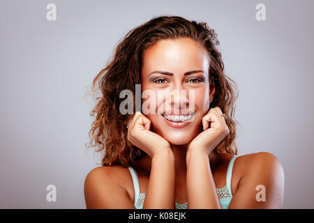 Le portrait d'une jeune femme montrant ses dents blanches parfaites avec accolades. looking at camera. Banque D'Images