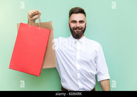 Homme barbu tenant des jeunes adultes avec de nombreux sacs de magasinage au centre commercial ou magasin. Studio shot Banque D'Images