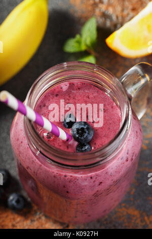 Les smoothies de myrtilles, banane et orange dans un bocal en verre, close-up. Boisson fraîchement préparés, de fruits rouges et de fruits Banque D'Images