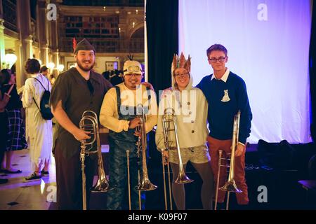 Quatre étudiants tous les trombones holding dressed in costumes, l'étudiant plus à gauche habillé en Peter pan, l'étudiant la deuxième à partir de la gauche, vêtu comme un favori du film 'Despicable Me' ; l'étudiante, la deuxième à partir de la l'homme portant une couronne brillante et cat constituent, l'étudiant plus à droite vêtu d'un pull bleu avec un dessin épinglé sur sa poitrine et le pantalon orange ; l'Halloween à Peabody, 31 octobre 2015. Banque D'Images