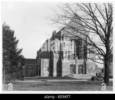 Photo de paysage d'une grande église en pierre à distance, avec une voiture noire garée devant, deux arbres, l'un avec des feuilles et de l'autre sans, en face de l'église, Roland Park/Guilford, Baltimore, Maryland, 1910. Cette image est tirée d'une série sur la construction et la vente de maisons dans le quartier Roland Park/Guilford de Baltimore, a streetcar suburb et l'une des premières communautés planifiées aux États-Unis. Le quartier a été isolé, et est considéré comme l'un des premiers exemples de l'application de la ségrégation raciale par l'utilisation d'alliances. Banque D'Images