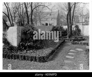 Photo de paysage de l'arrière-cour d'une maison avec une seule voie de pierre, de petits arbustes et d'une hauteur moyenne de mur, un grand arbre sans feuilles vers la gauche, d'autres maisons vue dans la distance, Roland Park/Guilford, Baltimore, Maryland, 1910. Cette image est tirée d'une série sur la construction et la vente de maisons dans le quartier Roland Park/Guilford de Baltimore, a streetcar suburb et l'une des premières communautés planifiées aux États-Unis. Le quartier a été isolé, et est considéré comme l'un des premiers exemples de l'application de la ségrégation raciale par l'utilisation de restreindre Banque D'Images