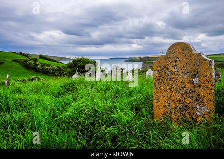 Des pierres tombales dans un petit cimetière le long de Kinsale harbour Banque D'Images