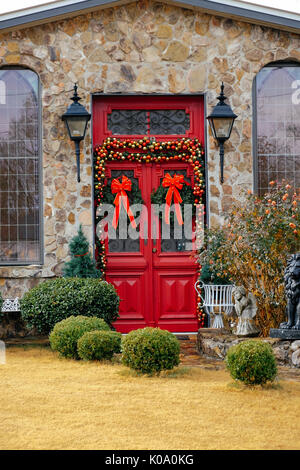 Une maison en pierre avec une porte double rouge décoré pour la saison de Noël dans les régions rurales de l'Alabama, United States. Banque D'Images