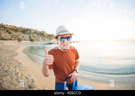 Man holding assurance et showing Thumbs up contre l'océan bleu. Concept de voyage. Banque D'Images