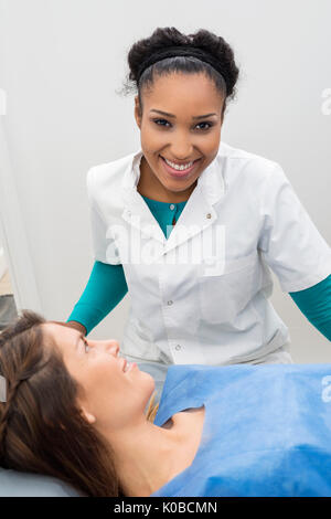 Smiling Doctor Standing by female patient en cours d'analyse à rayons X Banque D'Images