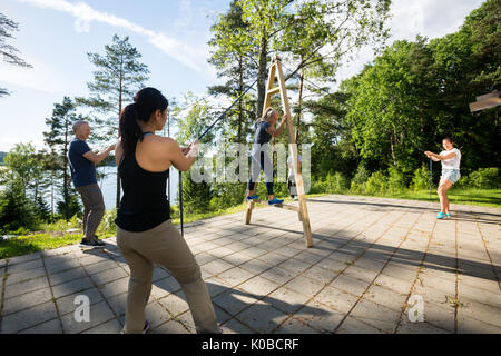 Les amis de cordes de traction pour équilibrer Femme sur Structure en bois Banque D'Images