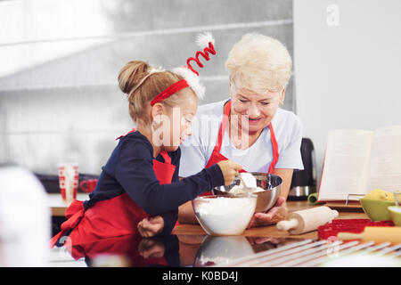 Grand-mère son petit-fils d'enseignement comment faire un gâteau Banque D'Images