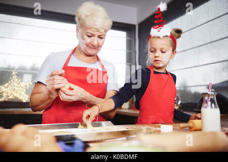 Girl putting les cookies sur la plaque Banque D'Images