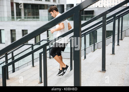 Vue latérale d'un athlète sportif homme qui court en bas au stadium Banque D'Images