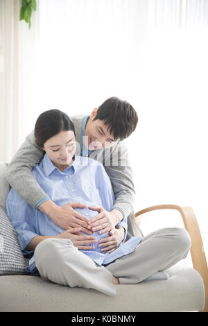 Enceinte harmonieux couple hugging Banque D'Images