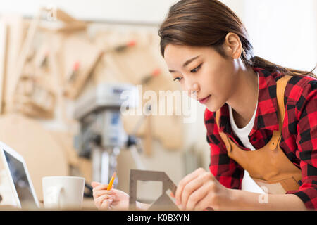 Side view portrait of young female designer de meubles se concentrant sur son travail Banque D'Images