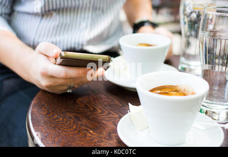 Fille à l'aide d'un téléphone dans un bar café Banque D'Images