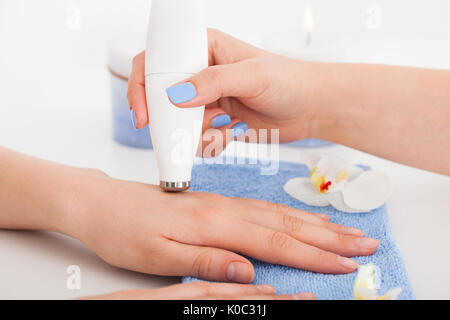 Image recadrée de manucure microdermabrasion donnant sur la thérapie woman's hand at beauty salon Banque D'Images