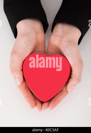 Tourné directement au-dessus de businesswoman holding heart shaped gift box en creux des mains à 24 Banque D'Images