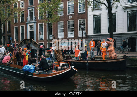 Amsterdam, Pays-Bas - 27 avril, 2017 : la population locale et les touristes habillés de vêtements orange et des costumes amusants ride sur les bateaux et participer à de célébrité Banque D'Images