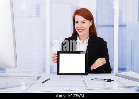 Portrait of young affichage écran vierge de digital tablet in office Banque D'Images