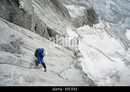 Jan solyga place protection pendant l'escalade de 'mon coeur espagnol' rock itinéraire sur petit jorasses face dans les Alpes françaises. glacier est visible en arrière-plan. Banque D'Images