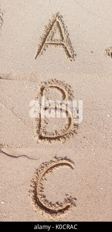 Alphabet (ABC) écrit sur le sable. Banque D'Images