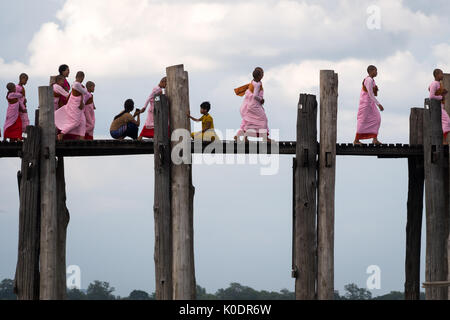 La croix des moines femmes U Bein Bridge le soir, Mandalay, Myanmar Banque D'Images