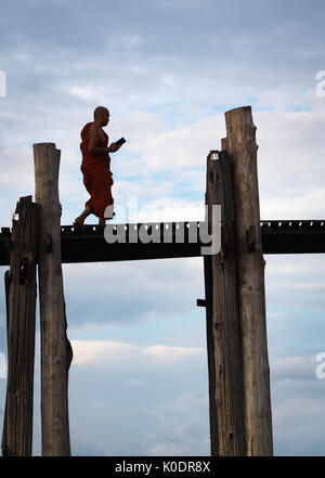 Le moine bouddhiste traverse le pont U Bein, le lac Taungthaman, Mandalay, Myanmar Banque D'Images