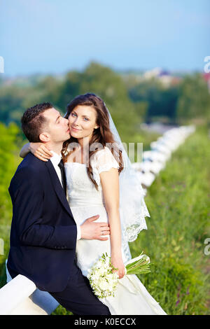 Happy Bride and Groom kissing smiling sur jour de mariage. Banque D'Images