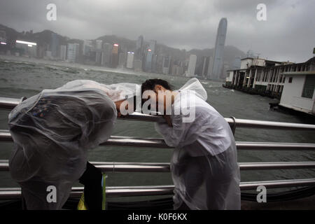 23 août 2017 - Hong Kong, Chine - Les touristes se sentent la forte rafale vent apporté par le cyclone tropical à la station de Kowloon. No.10 Typhoon sévère HATO frapper le territoire tôt le matin avec du vent soutenu maximales près du centre plus de 100mph, un cyclone forte rare jamais d'arriver à Hong Kong depuis plus d'une décennie. (Crédit Image : © Liau Chung Ren via Zuma sur le fil) Banque D'Images