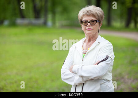 Portrait de senior trainer strict sérieuse femme debout avec les bras croisés, copyspace Banque D'Images