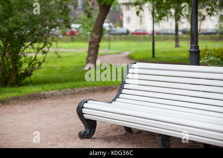 Long banc en bois peint en blanc est en été parc urbain, personne ne Banque D'Images