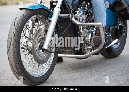 Close-up, en vue de l'avant pied motocycliste avec boot brown de protection sur les stands de moto avec arcs de protection chrome Banque D'Images