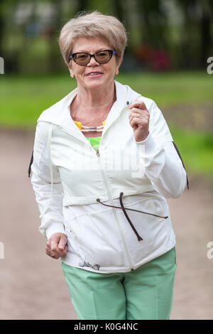 Portrait d'une femme européenne dans un survêtement en faisant du jogging dans le parc Banque D'Images