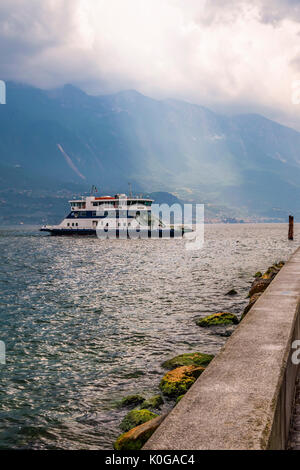 Car-ferry entre Malcesine et Limone sur le lac de Garde, pris sur un jour de tempête en été. Le soleil peut être vu briller à travers les nuages sur le Monte Baldo. Banque D'Images