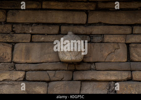 Une tête en pierre sur un mur de pierre dans le quartier historique de ruines de Chavin de Huantar, au Pérou. Banque D'Images