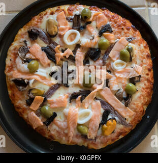 Pizza fruits de mer avec saumon, crevettes, olives, bagues de calmars Banque D'Images