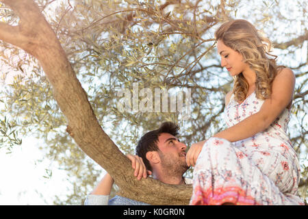 Couple d'amoureux sous un grand arbre dans le parc en automne Banque D'Images