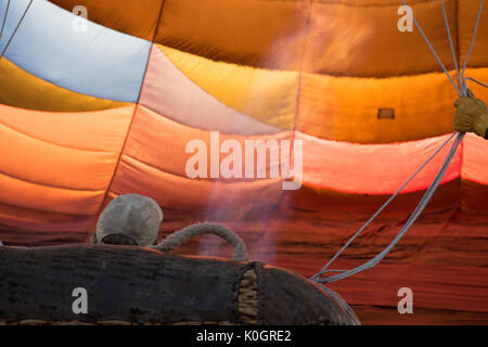 Un projet pilote de gonfler un ballon à air chaud tout en étant assis en face du panier. Les flammes sont visibles dans l'image. Banque D'Images