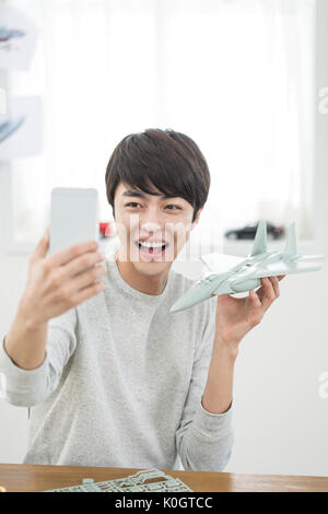 Portrait of smiling male kidult avec maquette avion selfies qui pose pour Banque D'Images