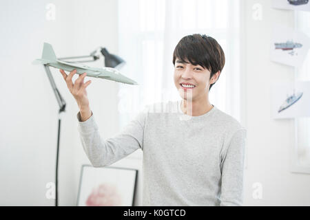 Portrait of smiling male kidult jouant avec un modèle réduit d'avion Banque D'Images