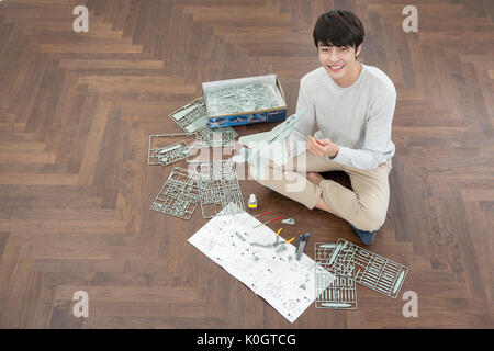 Portrait of smiling male kidult jouant avec maquette avion Banque D'Images