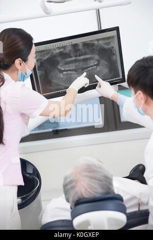 L'hygiéniste dentaire et le dentiste montrant x-ray photo à un patient Banque D'Images