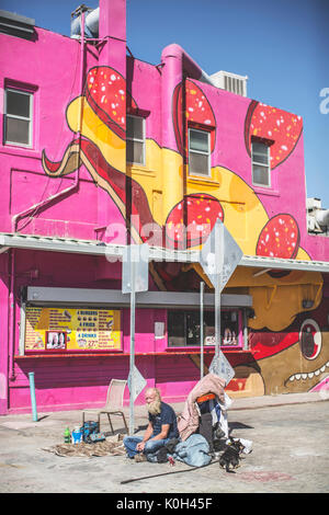 Los Angeles, États-Unis d'Amérique - 25 octobre, 2016. Un sans-abri assis avec son chien dans le soleil, Los Angeles. Banque D'Images