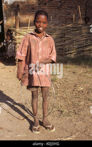 Saora garçon tribal cerceau roulant dans un village de Odisha (Orissa), Inde Banque D'Images