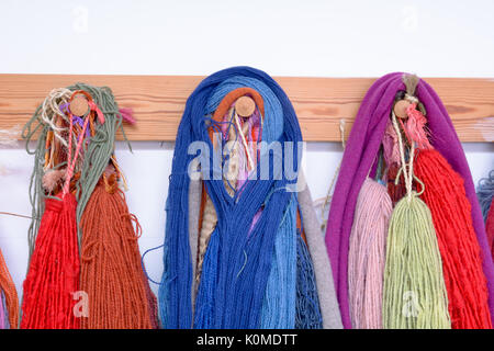 Hand Dyed et laine filées avec une gamme de coloris éclatants hanging on pegs en studio Banque D'Images