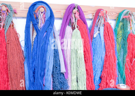 Hand Dyed et laine filées avec une gamme de coloris éclatants hanging on pegs en studio Banque D'Images