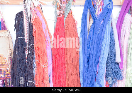 Hand Dyed et laine filées avec une gamme de coloris éclatants hanging on pegs en studio Banque D'Images