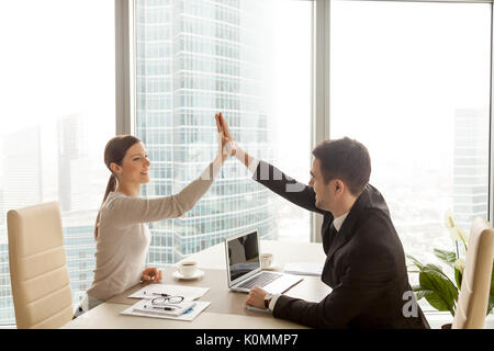 Businessman businesswoman at office high five, côté ville Banque D'Images