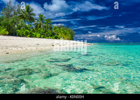 La plage magnifique de sable blanc et de rochers noirs sur Rarotonga, îles Cook Banque D'Images