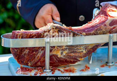 Waiter est slicing raw ham,italien Banque D'Images